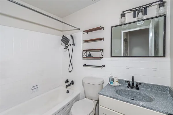 a bathroom with a granite countertop sink toilet and shower