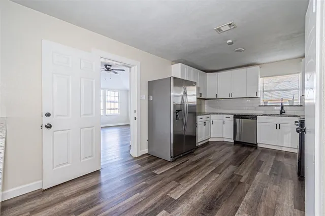 a kitchen with stainless steel appliances a refrigerator sink and cabinets
