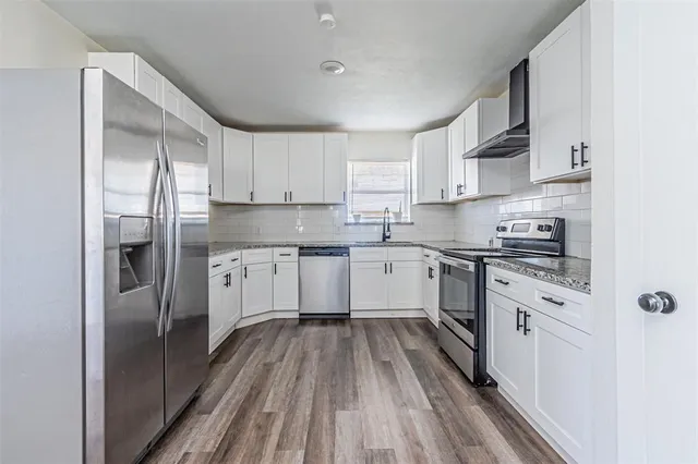 a kitchen with white cabinets stainless steel appliances and a sink
