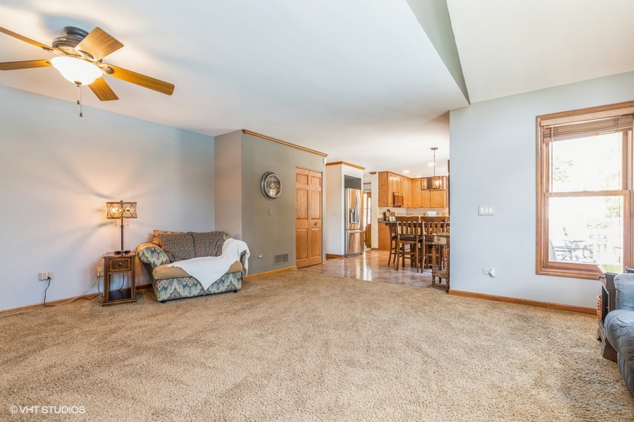 198 Foxmoor Road Fox River Grove, IL 60021 - Photo 11 of 26 a spacious bedroom with a bed a table and painting on the wall
