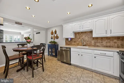 a kitchen with sink cabinets and dining table chair
