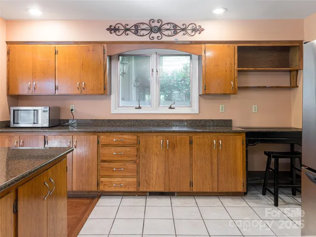a sink with wooden cabinets and a window