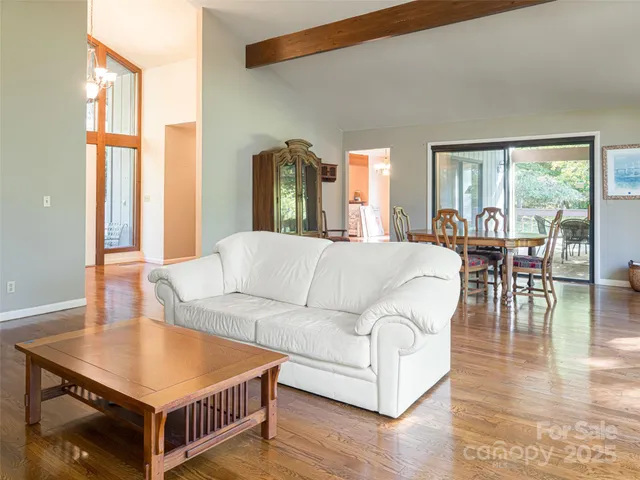 a living room with furniture and a large window with wooden floor