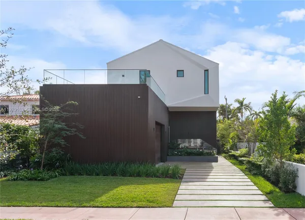 a front view of a house with a yard and trees
