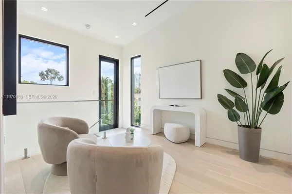a living room with furniture a potted plant and a lamp