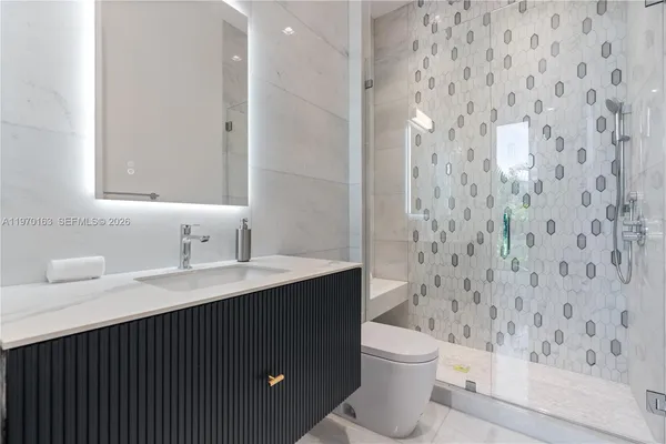 a bathroom with a granite countertop sink a toilet and a mirror