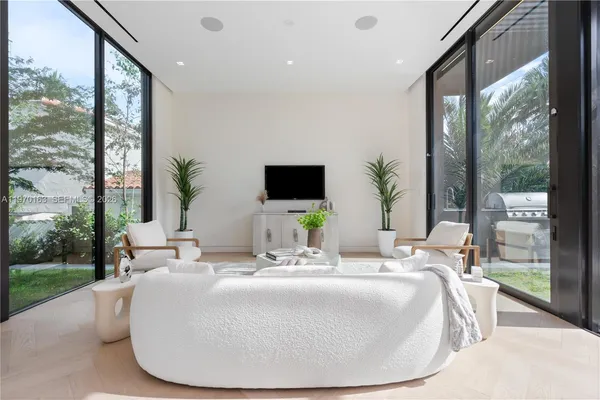 a living room with couch potted plant and a large window