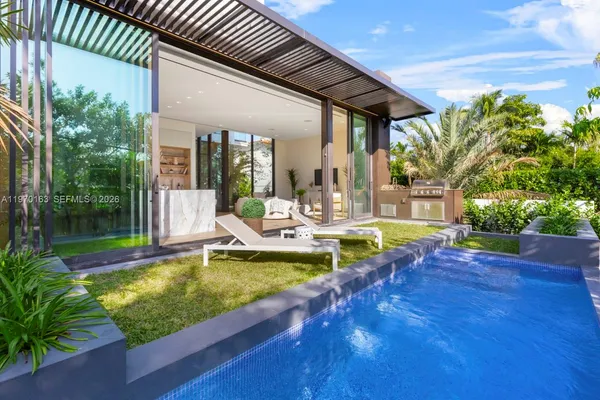 a view of a swimming pool with lounge chair in front of house