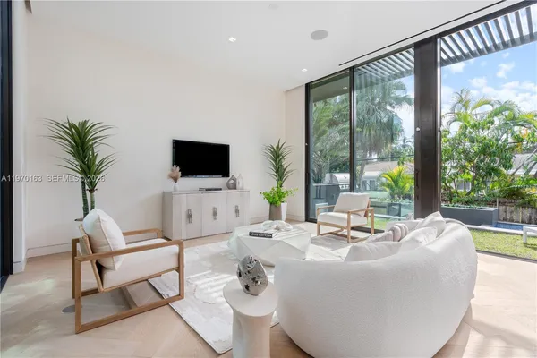 a living room with patio furniture and a flat screen tv