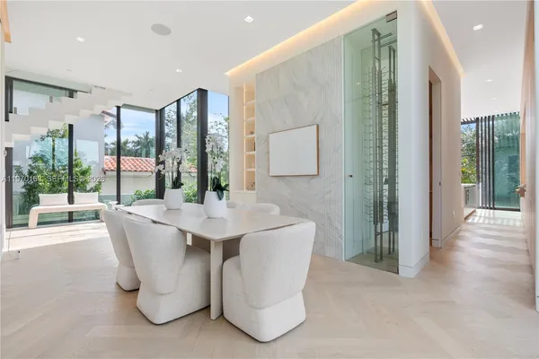 a living room with large windows a table and chairs