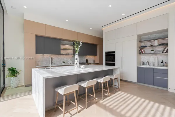 a large kitchen with kitchen island a dining table and chairs