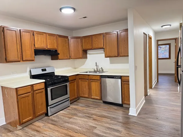 a kitchen with granite countertop wooden floors and stainless steel appliances