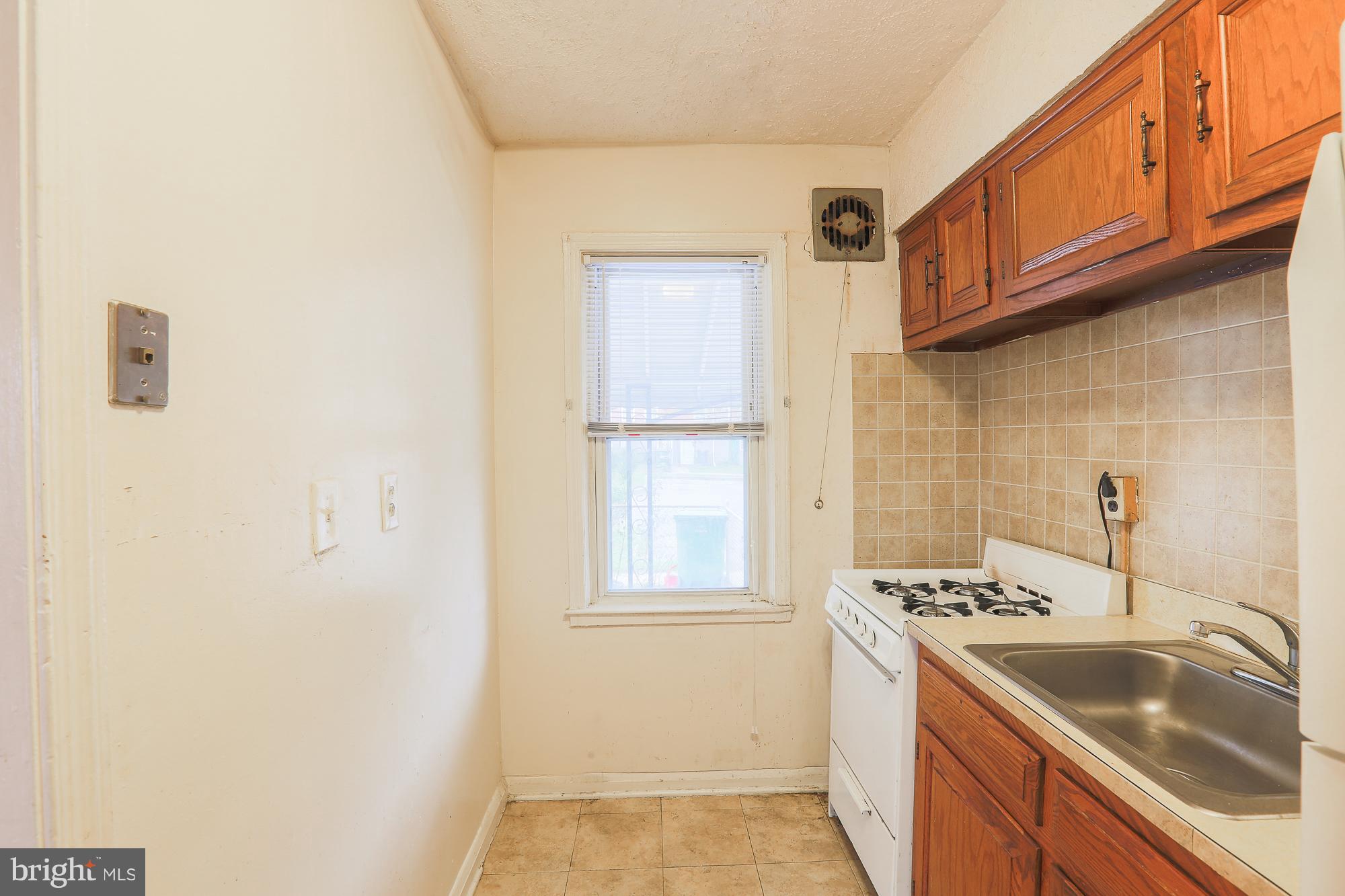 1046 Tunbridge Road Baltimore, MD 21212 - Photo 17 of 30 a kitchen that has a sink a stove and a window