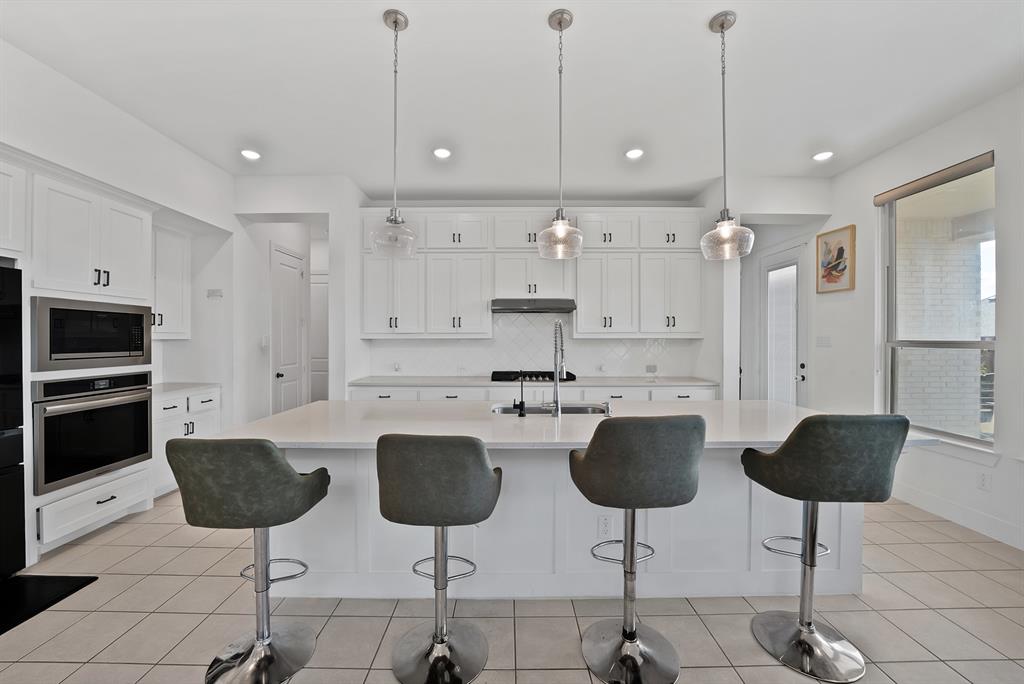 4222 Crown Run Road Midlothian, TX 76065 - Photo 6 of 40 White shaker cabinetry, built-in stainless steel appliances, a large center island, and tiled flooring