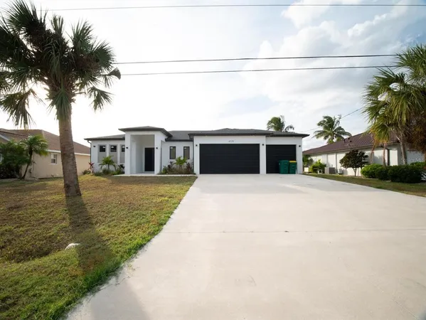 a front view of a house with a garden and trees