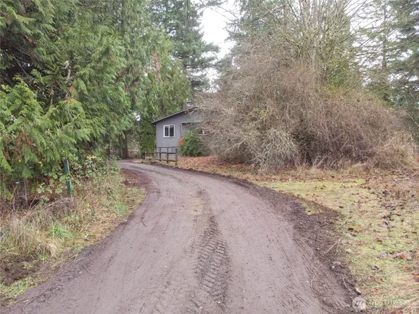 a view of a dirt road with a building in the background