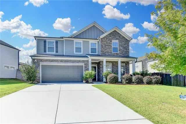 a front view of a house with a yard and garage