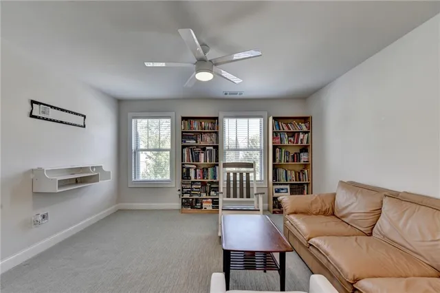a living room with furniture and a book shelf