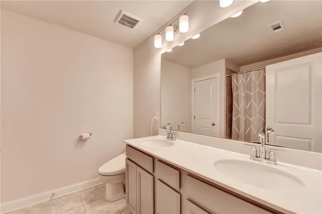 a bathroom with a sink a toilet and a large mirror