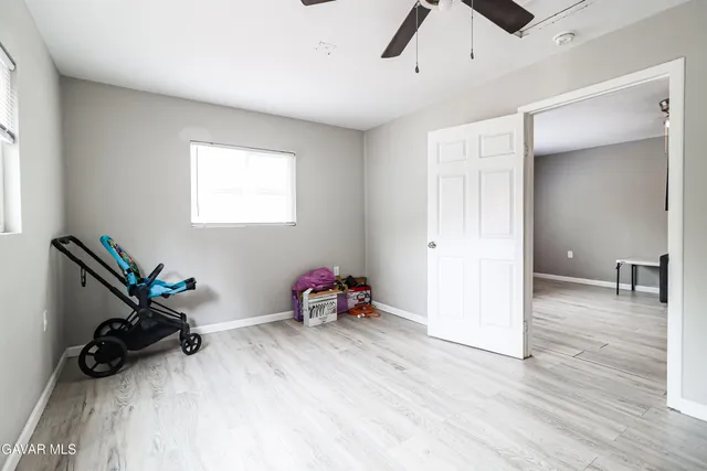 a view of a room with gym equipment and wooden floor