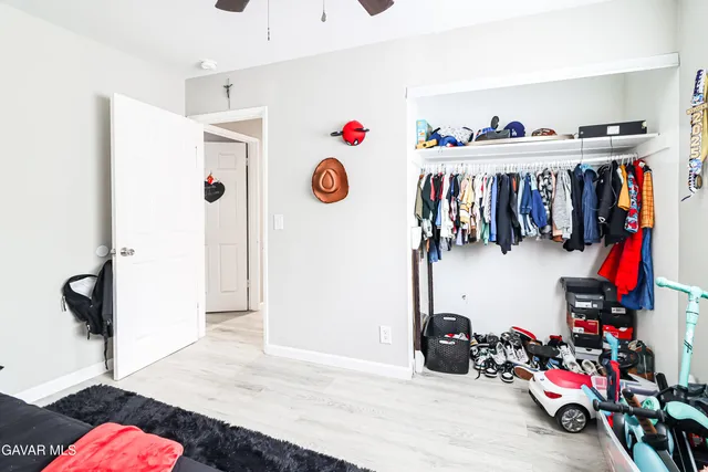 a view of walk in closet with clothes and shoes
