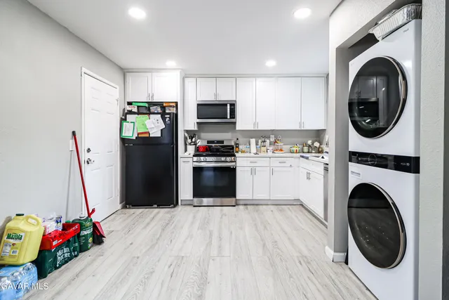 a kitchen with a refrigerator sink and cabinets