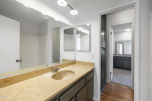 a bathroom with a granite countertop sink and a mirror