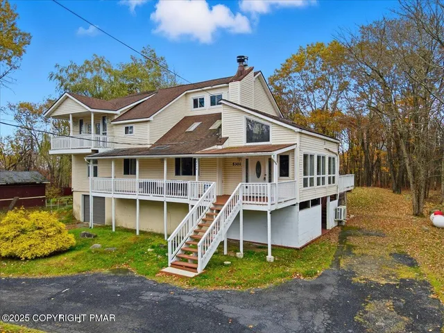a view of a house with a yard and wooden fence