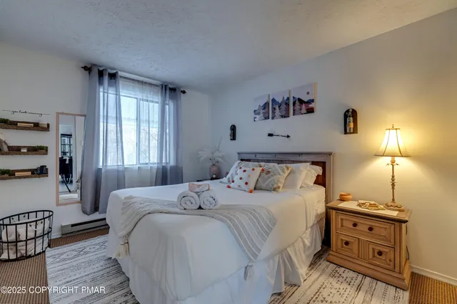 a view of a white house with a snow in the middle of a yard