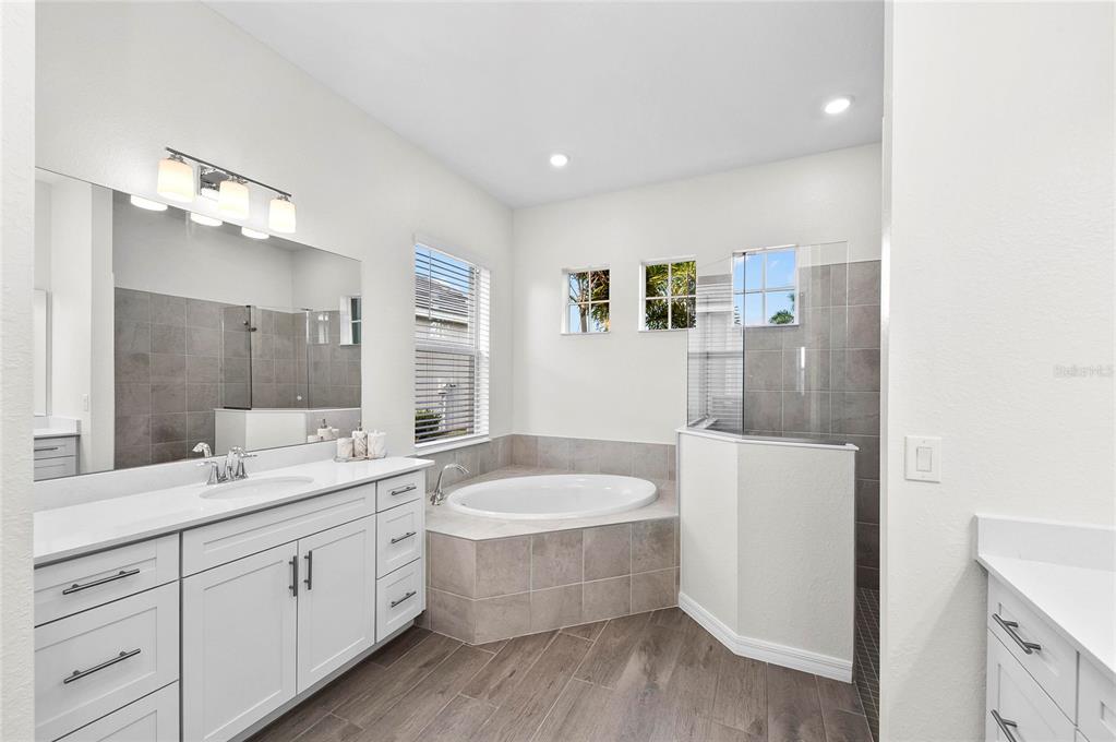 17341 Sandpearl Road Venice, FL 34293 - Photo 35 of 95 a spacious bathroom with a double vanity sink a mirror and a bathtub