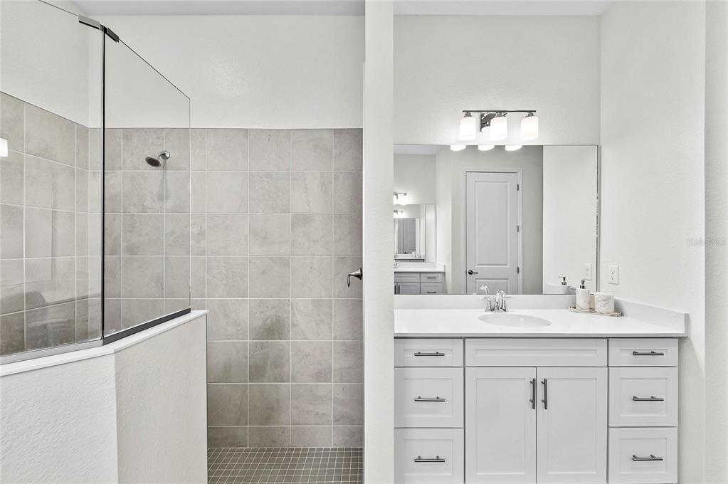 17341 Sandpearl Road Venice, FL 34293 - Photo 36 of 95 a bathroom with a double vanity sink mirror and shower