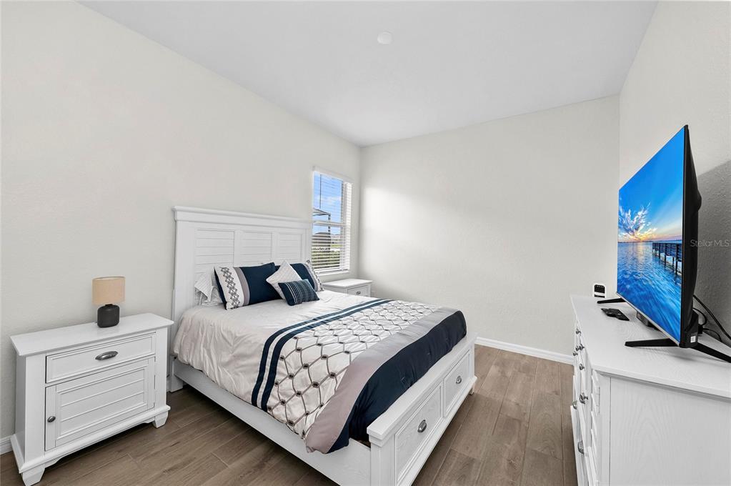 17341 Sandpearl Road Venice, FL 34293 - Photo 41 of 95 a bedroom with a bed and a flat screen tv