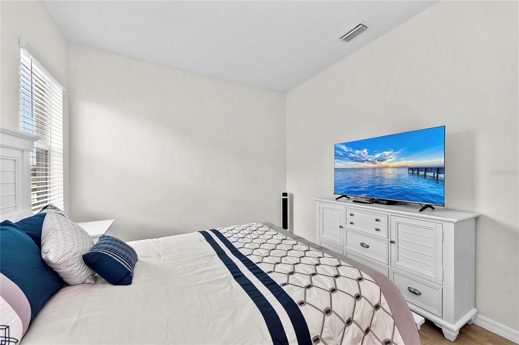 17341 Sandpearl Road Venice, FL 34293 - Photo 42 of 95 a bedroom with a bed and a flat screen tv