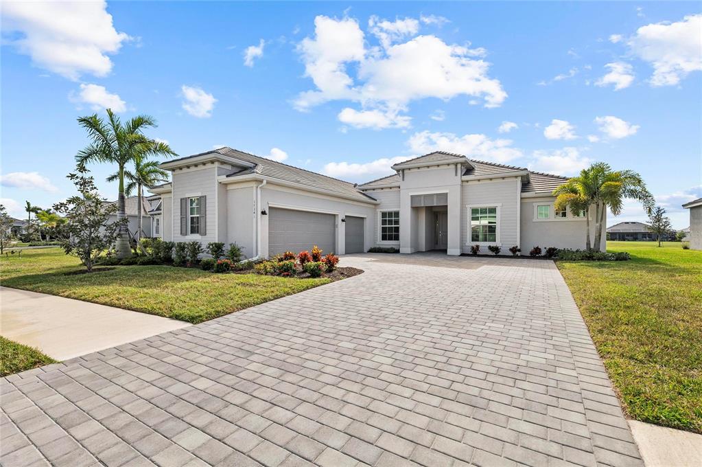 17341 Sandpearl Road Venice, FL 34293 - Photo 68 of 95 a front view of a house with a yard and potted plants