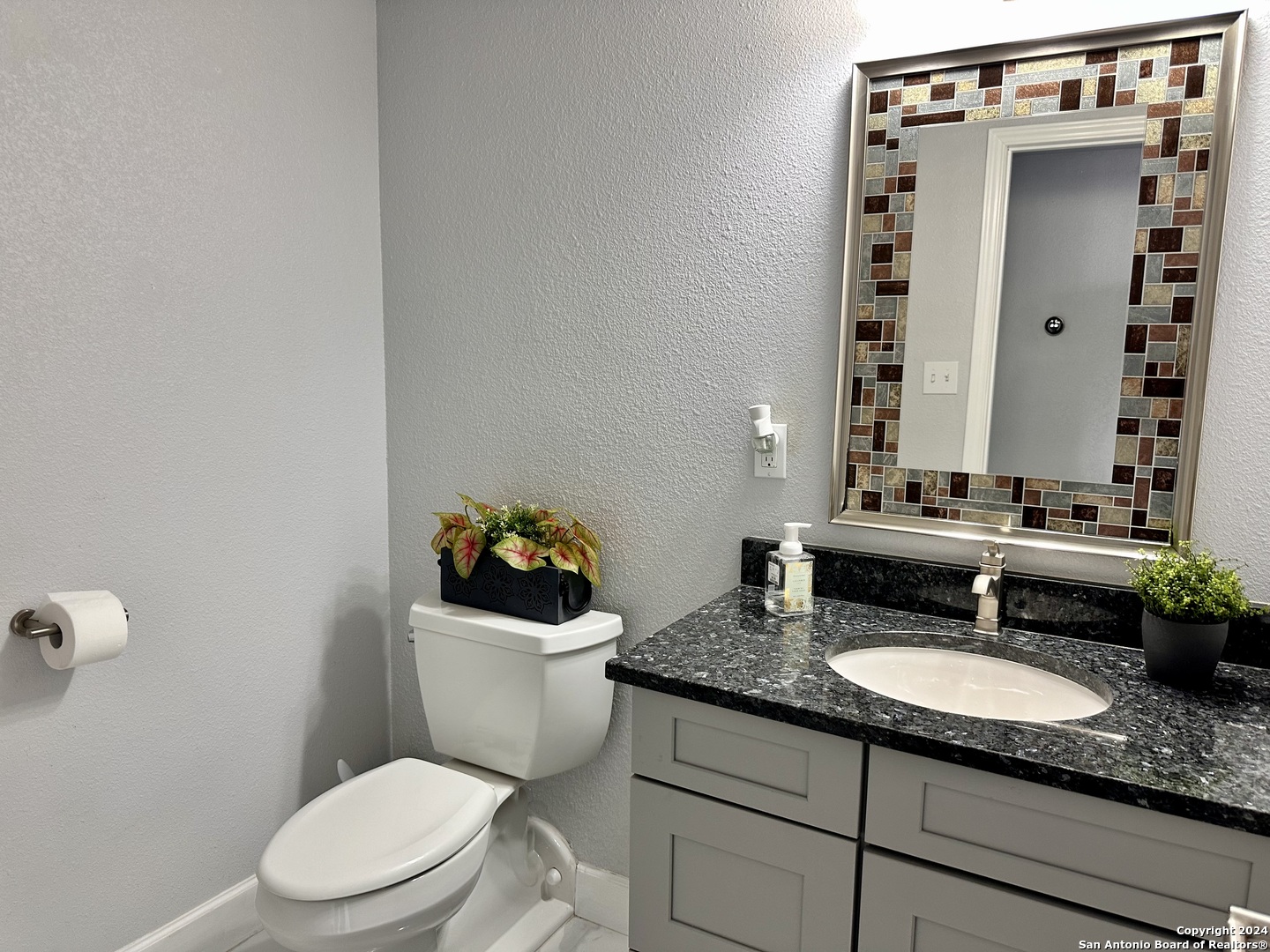 7701 Wurzbach Road, Unit 2301 San Antonio, TX 78229 - Photo 20 of 36 a bathroom with a granite countertop toilet sink and mirror