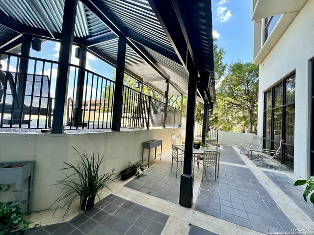 a view of a patio with table and chairs with barbeque grill and plants