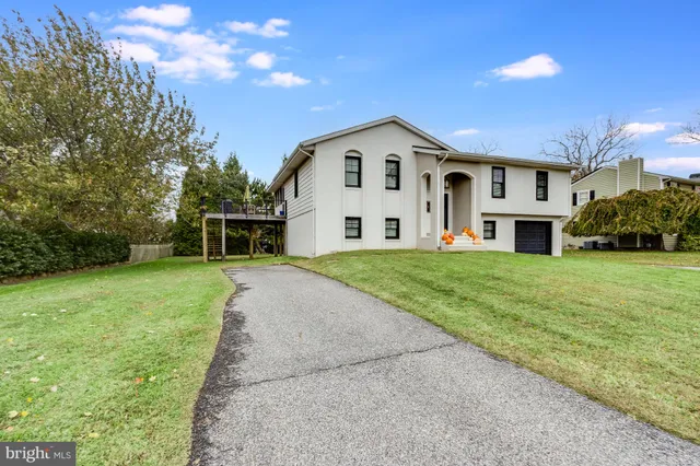 a front view of a house with yard and green space