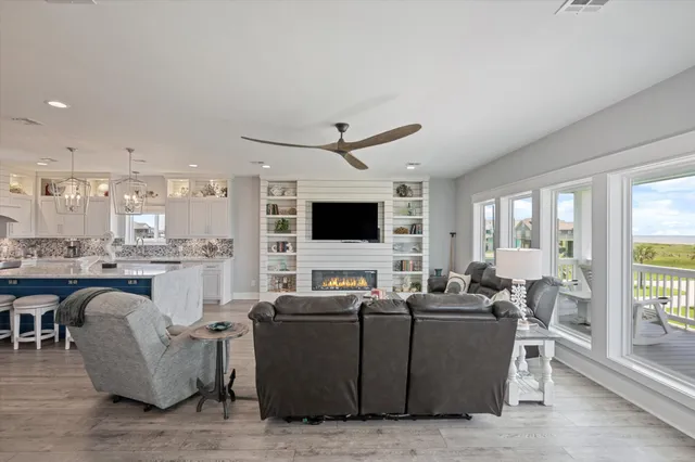 a large kitchen with stainless steel appliances granite countertop a sink dishwasher a stove and a dining table with wooden floor