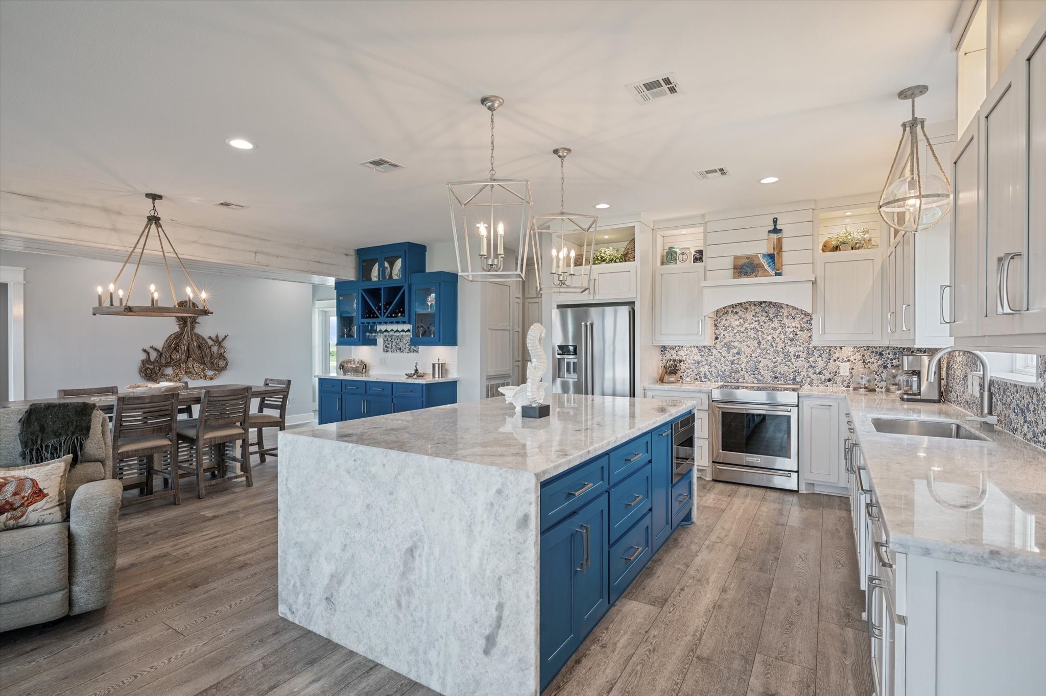 3701 Biscayne Beach Road Port Bolivar, TX 77650 - Photo 25 of 50 a large kitchen with stainless steel appliances granite countertop a sink dishwasher a stove and a dining table with wooden floor
