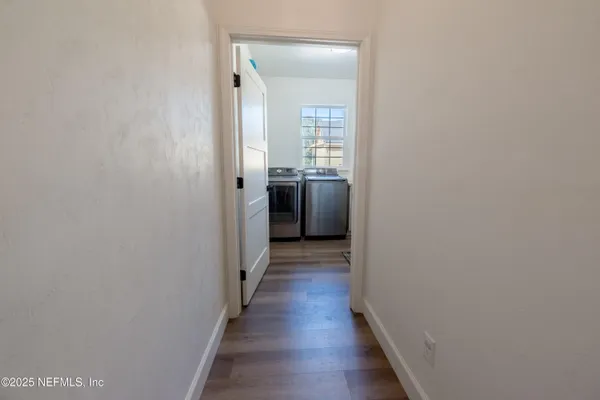 a view of a hallway with wooden floor and staircase