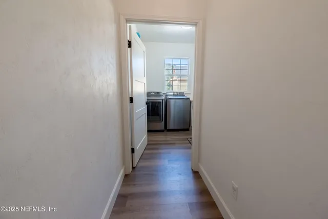 a view of a hallway with wooden floor and staircase