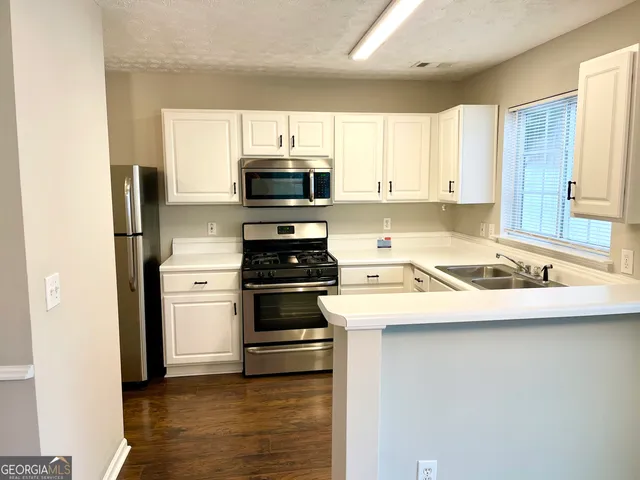 a kitchen with appliances a sink and a microwave
