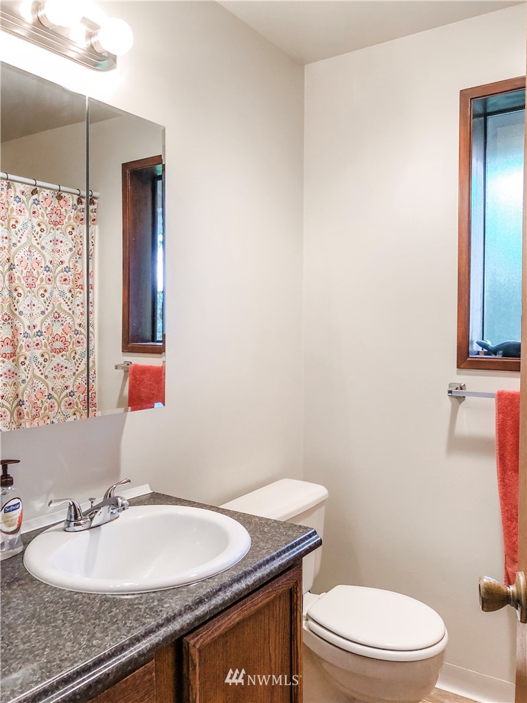2121 Chestnut Street Everett, WA 98201 - Photo 12 of 21 a bathroom with a granite countertop toilet a sink and a mirror