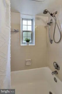 a bathroom with a bath tub with a shower