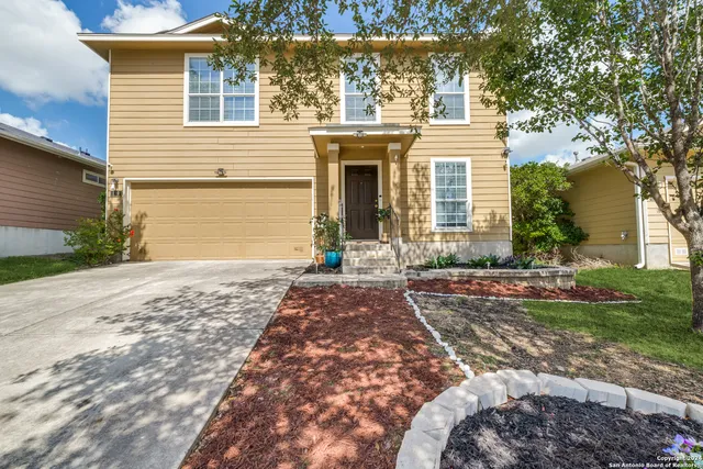 a front view of a house with a yard and a garage