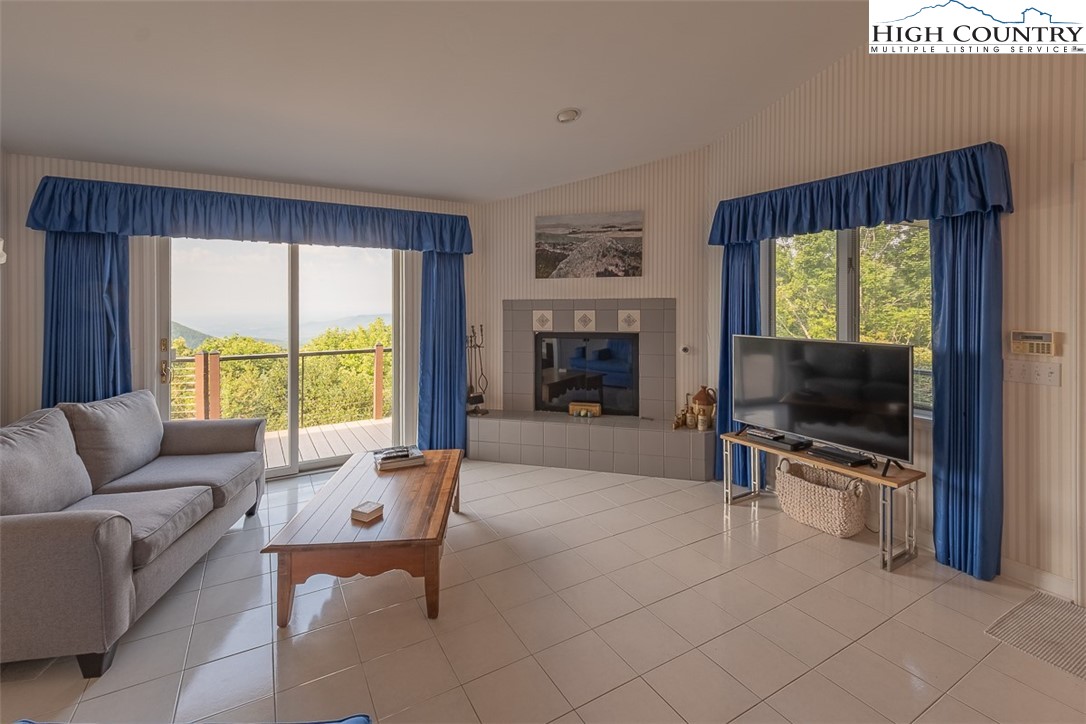 148 Chestnut Ridge Lane Glade Valley, NC 28627 - Photo 14 of 50 a living room with furniture a flat screen tv and a fireplace