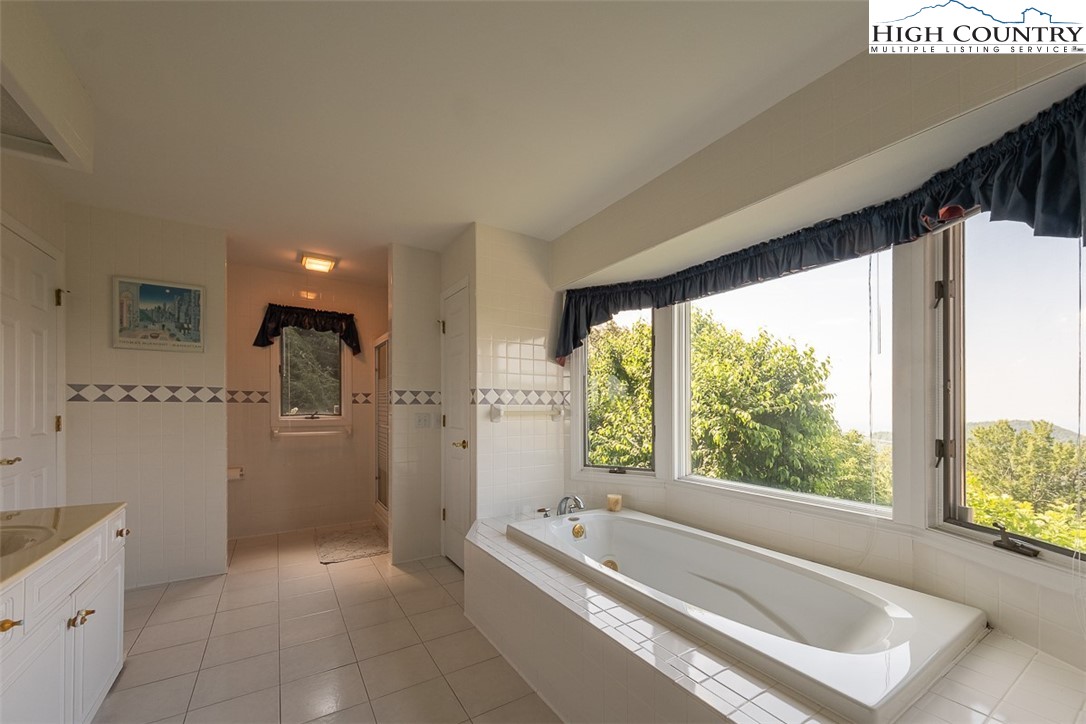 148 Chestnut Ridge Lane Glade Valley, NC 28627 - Photo 19 of 50 a spacious bathroom with a tub sink and mirror