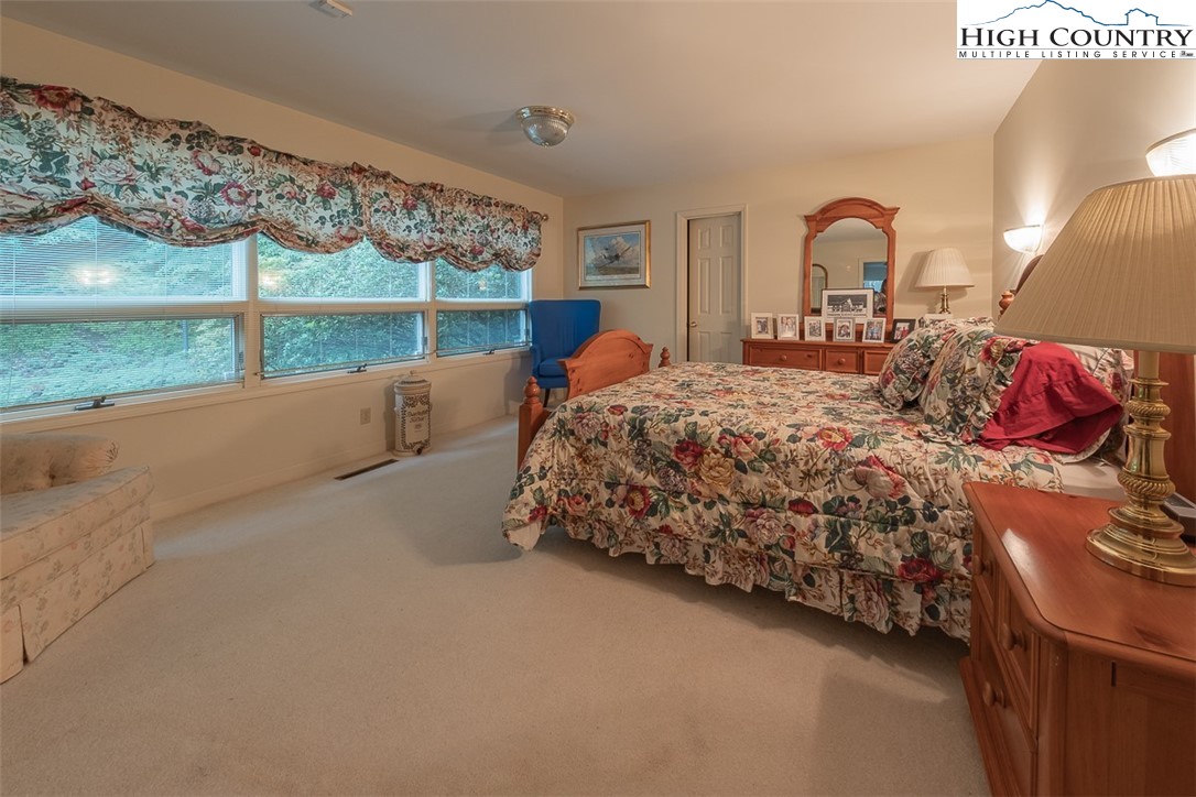 148 Chestnut Ridge Lane Glade Valley, NC 28627 - Photo 22 of 50 a bed sitting in a bedroom next to a window