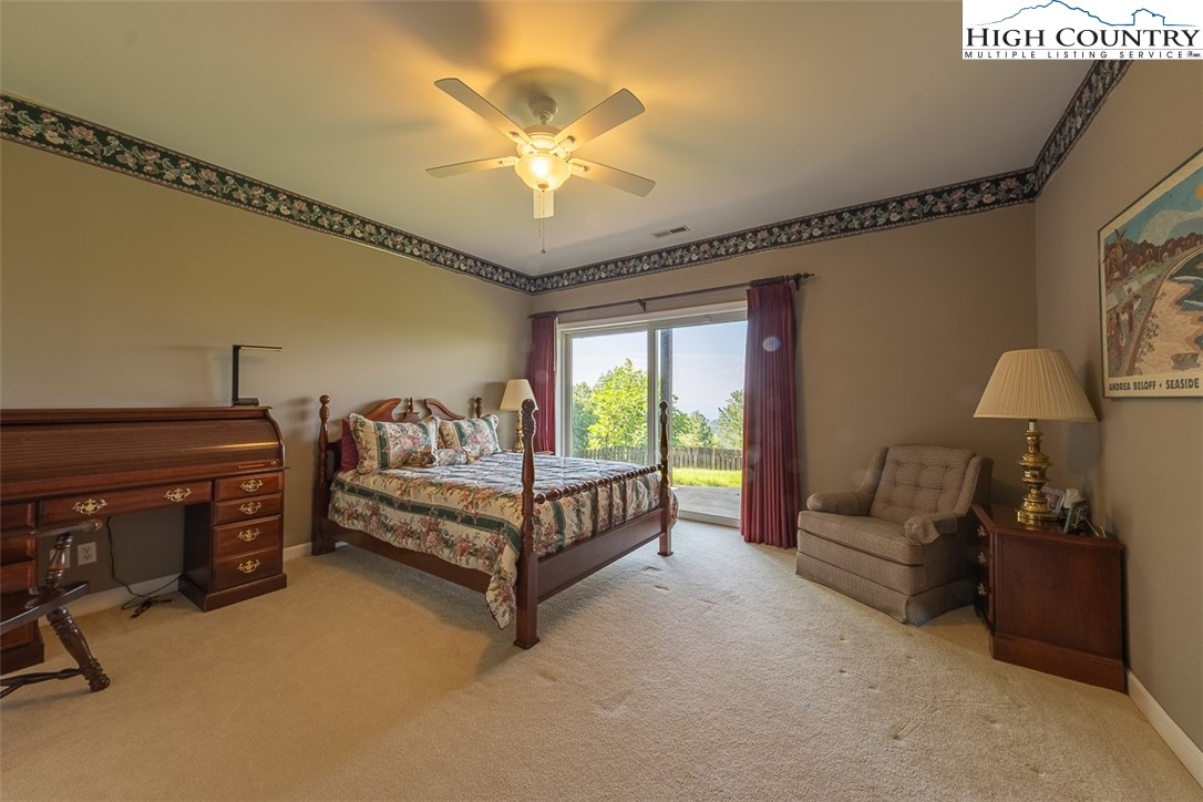 148 Chestnut Ridge Lane Glade Valley, NC 28627 - Photo 31 of 50 a spacious bedroom with a bed and a chandelier
