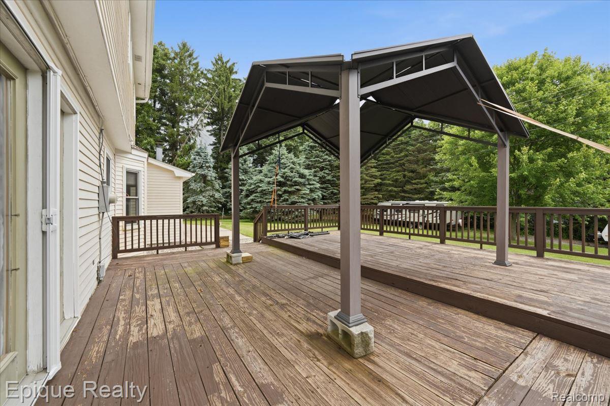 1221 Rhodes Road Lake Orion, MI 48360 - Photo 58 of 72 Expansive wood deck featuring a covered gazebo structure, perimeter railing, and mature evergreen trees